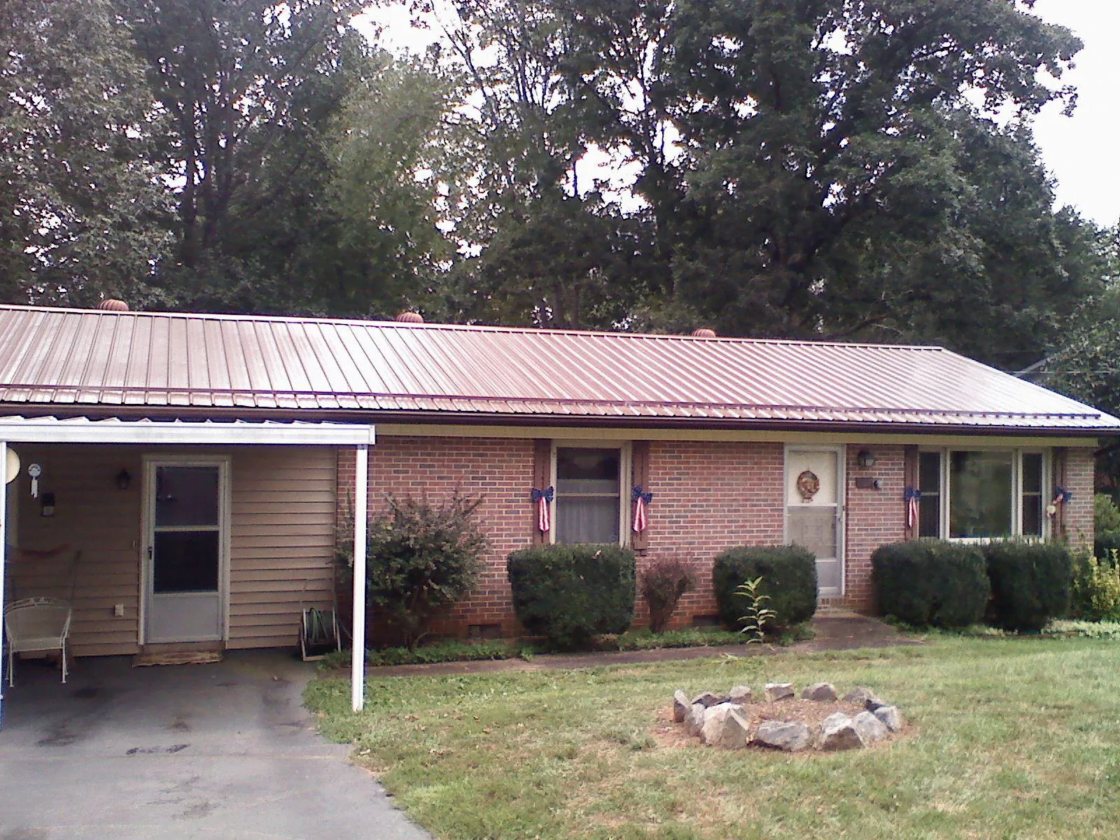 Bronze metal roof and carport on a brick ranch home — Roof Repair work by our crew in Bowman